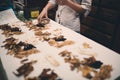 Traditional Asian herbal medicine practitioner filling with ingredients for treatment