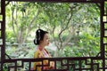 Traditional Asian Japanese beautiful Geisha woman wears kimono with a fan on hand in a summer nature