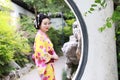 Traditional Asian Japanese beautiful woman bride wears kimono stand in outdoor spring garden Royalty Free Stock Photo