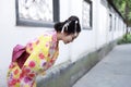 Traditional Asian Japanese beautiful woman wears kimono in a spring garden park bow