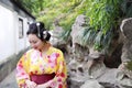 Traditional Asian Japanese beautiful woman wears kimono in a spring garden park stand by bamboo enjoy free time Royalty Free Stock Photo