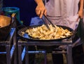 Traditional Asian Thai street food and fast food, delicious hot pan fried nidamental glands of cuttlefish in food market