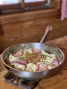 Traditional Austrian dish with noodles, cheese and ham in a pan