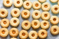 Traditional Austrian home baked Christmas cookies Linzer eyes with apricot jam on baking tray. Process of preparation. Cozy