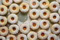 Traditional Austrian home baked Christmas cookies Linzer eyes with apricot jam powdered on baking tray. Process of preparation