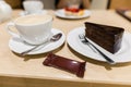 Traditional austrian sachertorte on plate on wooden background. Chocolate cake and a cup of coffee. Royalty Free Stock Photo