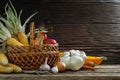 Traditional autumn set of ripe vegetables and fruits with a wicker basket on rough boards on a dark wooden background. artistic Royalty Free Stock Photo