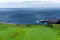 Azorean green fields bordered by stone walls, overlooking the Atlantic Ocean.