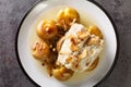 Traditional Bacalhau a Lagareiro Grilled Salted Cod with Olive Oil served with baked Potatoes closeup in the plate. Horizontal top Royalty Free Stock Photo