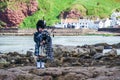 Traditional bagpiper in full dress code near Pennan Royalty Free Stock Photo