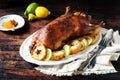 Traditional baked duck with apples and lemon on a dark wooden table Royalty Free Stock Photo