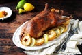 Traditional baked duck with apples and lemon on a dark wooden table Royalty Free Stock Photo