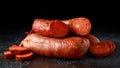 Traditional Balearic raw cured meat sobrassada sausage made from ground pork, paprika and spices on rustic black