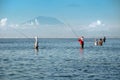 Traditional Balinese fishermen standing in shallow water at low tide on the beach at Nusa Dua Royalty Free Stock Photo