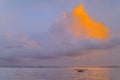 Traditional Balinese fishing boat in the sea against the sunset sky. Beautiful seascape at sunset on Sanur beach. Royalty Free Stock Photo