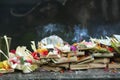 Traditional balinese offerings to gods in Bali with flowers, fruits and aromatic incense sticks