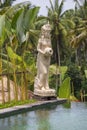Traditional balinese stone sculpture near swimming pool . Bali, Ubud, Indonesia