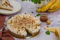 Traditional Banoffee pie with fresh bananas, whipped cream, chocolate, coffee and toffee. No baking dessert.