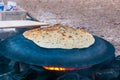 Traditional bedouin cake cooking on round semi sphere metal plate on fire in Eilat