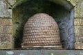 A traditional bee skep in a wall alcove