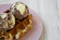 Traditional belgian waffle with icecream on pink plate over white wooden surface, side view. Close-up Royalty Free Stock Photo