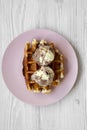 Traditional belgian waffle with icecream on pink plate over white wooden surface, top view. Close-up Royalty Free Stock Photo