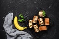 Traditional Belgian waffles with banana and ice cream on a black grunge background. View from above