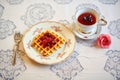 traditional belgian waffles with cherry compote on a lace doily