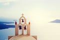 Traditional bells and cross over Aegean sea. Santorini Greece