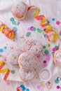 Traditional Berliner for carnival and party. German Krapfen or donuts with streamers and confetti. Colorful carnival or birthday Royalty Free Stock Photo