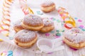 Traditional Berliner for carnival and party. German Krapfen or donuts with streamers and confetti. Colorful carnival or birthday Royalty Free Stock Photo