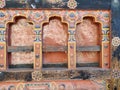 Traditional Bhutanese windows with intricate patterns on a decorated wall, bhutan Royalty Free Stock Photo