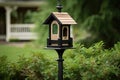 traditional birdhouse with matching feeder on classic black pole