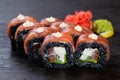 .traditional black Japanese sushi with salmon and soft cheese cucumber and red caviar garnished with sauce and white sesame Royalty Free Stock Photo