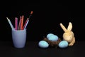 traditional blue eggs in nest and mug with pencils and brush