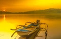 Traditional boat moored on the calm and tranquil lake during sunrise in Jatibarang Dam, Semarang, Indonesia. Royalty Free Stock Photo
