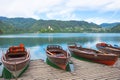 Traditional boats waiting for tourists on Lake Bled, with the lake island and charming little church in the background, famous Royalty Free Stock Photo