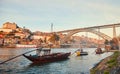 Traditional boats with wine barrels on Douro river in old Porto with background of Dom Luis bridge, Portugal Royalty Free Stock Photo
