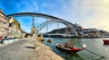 Traditional boats with wine barrels on Douro river in old Porto with background of Dom Luis bridge, Portugal Royalty Free Stock Photo