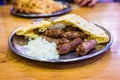 Traditional bosnian barbecue dish cevapi served with somun and chopped onions. Famous balkan BBQ dish served on an inox plate in