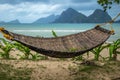 Traditional braided hammock in the shade with tropical island in the background