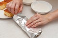 Traditional Brazilian dessert known as BOLO GELADO in Portuguese - Making step by step: Woman hand wrapping sliced cake Royalty Free Stock Photo