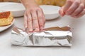 Traditional Brazilian dessert known as BOLO GELADO in Portuguese - Making step by step: Woman hand wrapping sliced cake Royalty Free Stock Photo