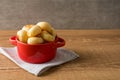 Traditional Brazilian Snack Cheese Bread in a rustic red cooking pot. On a wooden table background. with copy space