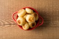 Traditional Brazilian Snack Cheese Bread in a rustic red cooking pot. On a wooden table background. with copy space