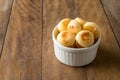 Traditional Brazilian Snack Cheese Bread in a white pot. On a wooden table background. copy space