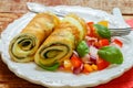 A traditional Breakfast. Omelette with spinach and a fresh tomato salad, red onion and Basil. Roll scrambled eggs Royalty Free Stock Photo