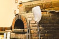 Traditional brick oven. Pizza paddle leaning against stone.