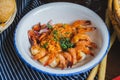 Traditional bright shrimp risotto in a bowl on a table in a restaurant with a beautiful decor in a dark key close-up.