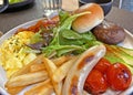 Traditional British all day breakfast dish, sausage, bacon, mushroom, tomato, bread, egg, fries and vegetable Royalty Free Stock Photo